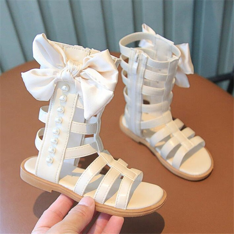 Your little princess will be the belle of the ball in these Girls Princess Bow Pearl High-Top Sandals!